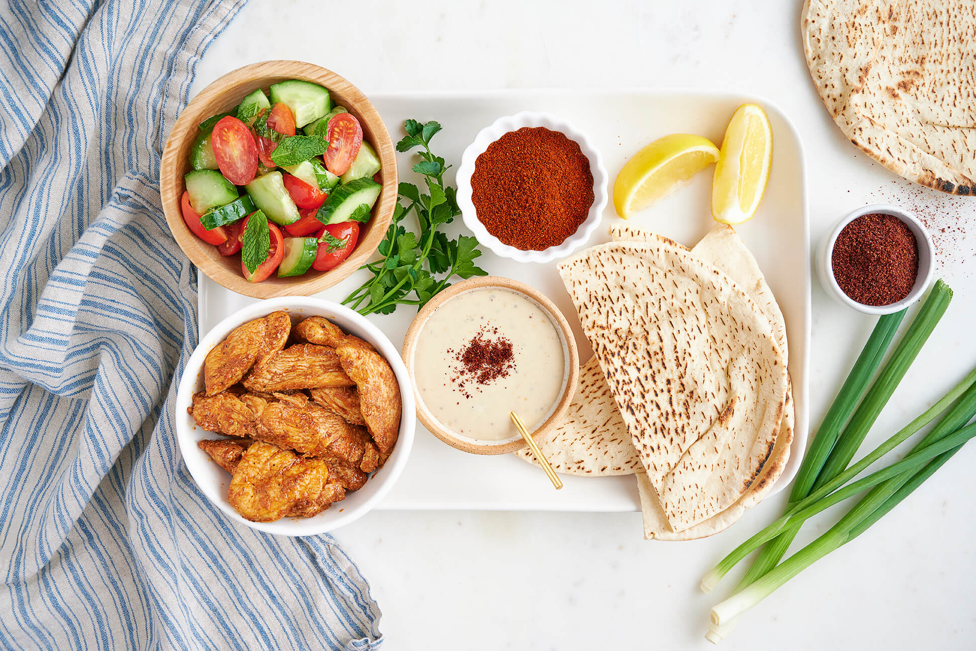 chicken with pita, tahini sauce, and cucumber salad