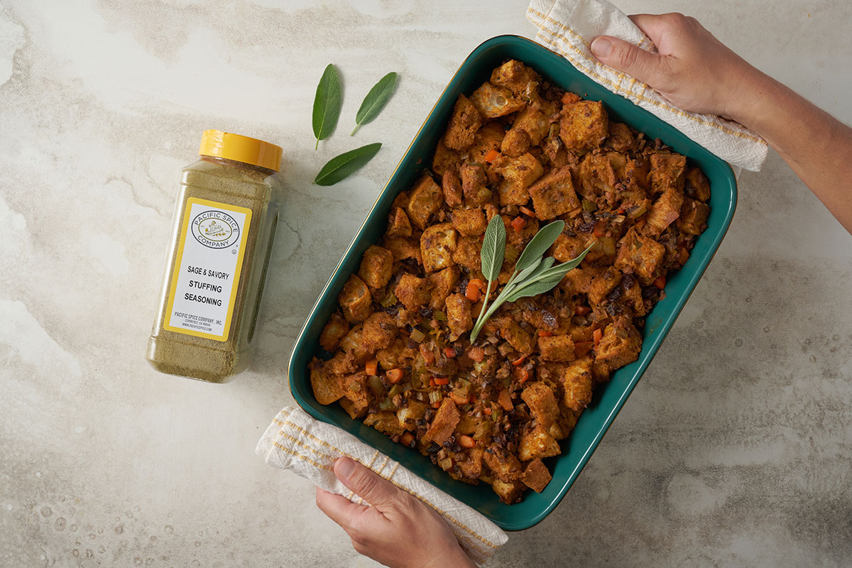 A horizontal overhead shot of Pacific Spice Company’s Vegetarian Stuffing Casserole, showcasing the golden, crispy top and the rich flavor of PSC Sage and Savory Stuffing Seasoning.